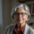 Portrait of June Emerson, author of Senior Sleep Solutions, wearing glasses and a red collared shirt